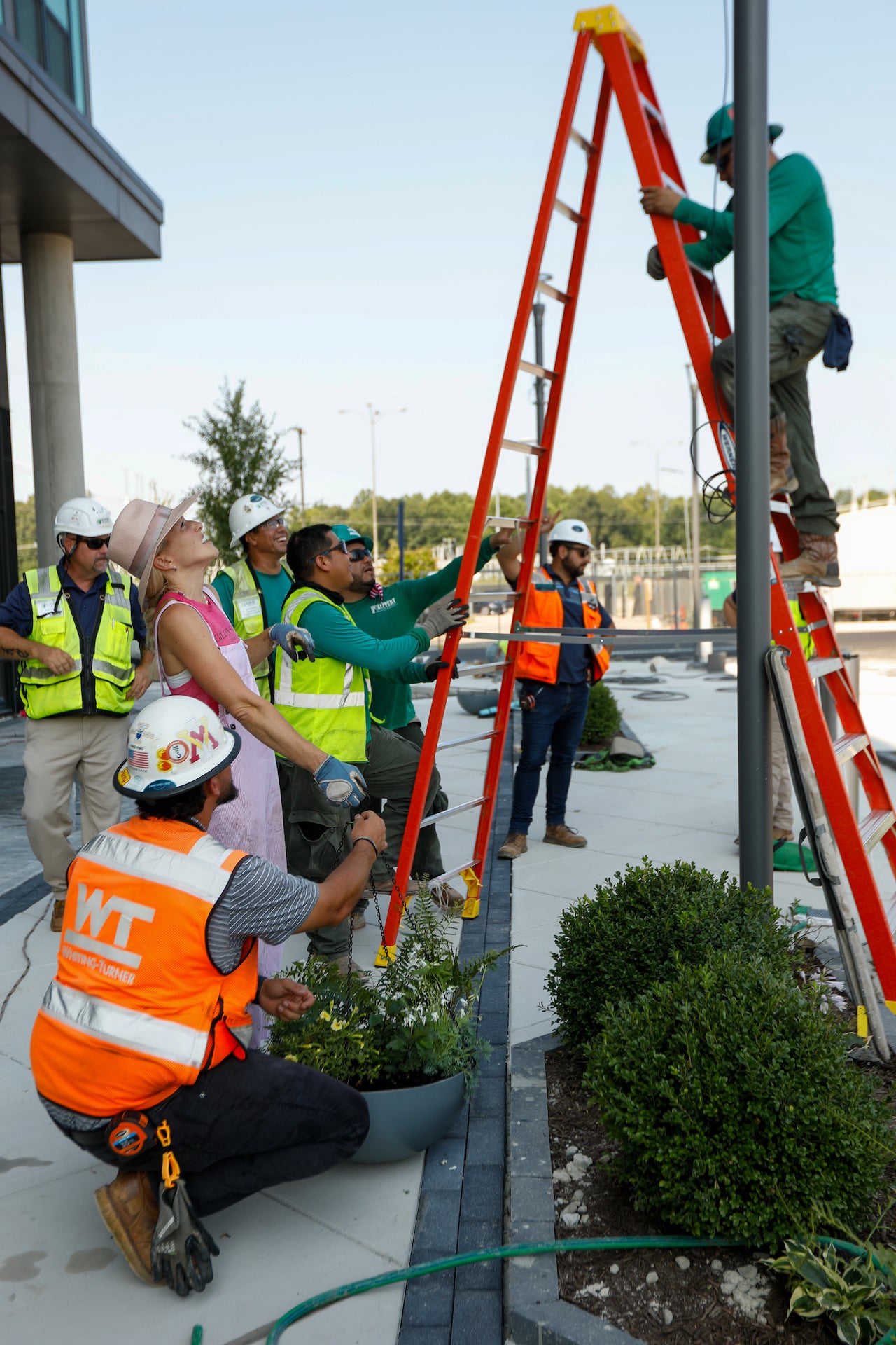Group of workers in safety vests and hard hats working on a construction or landscaping project.